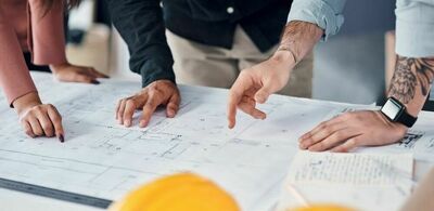 En gruppe mennesker studerer plantegninger