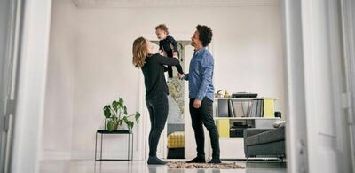 En familie holder barnet sitt i en stue